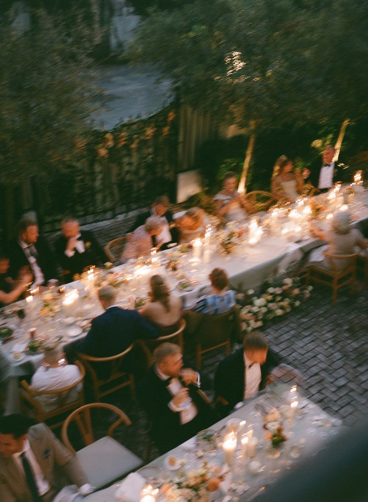 A candlelit outdoor dinner styled with olive trees